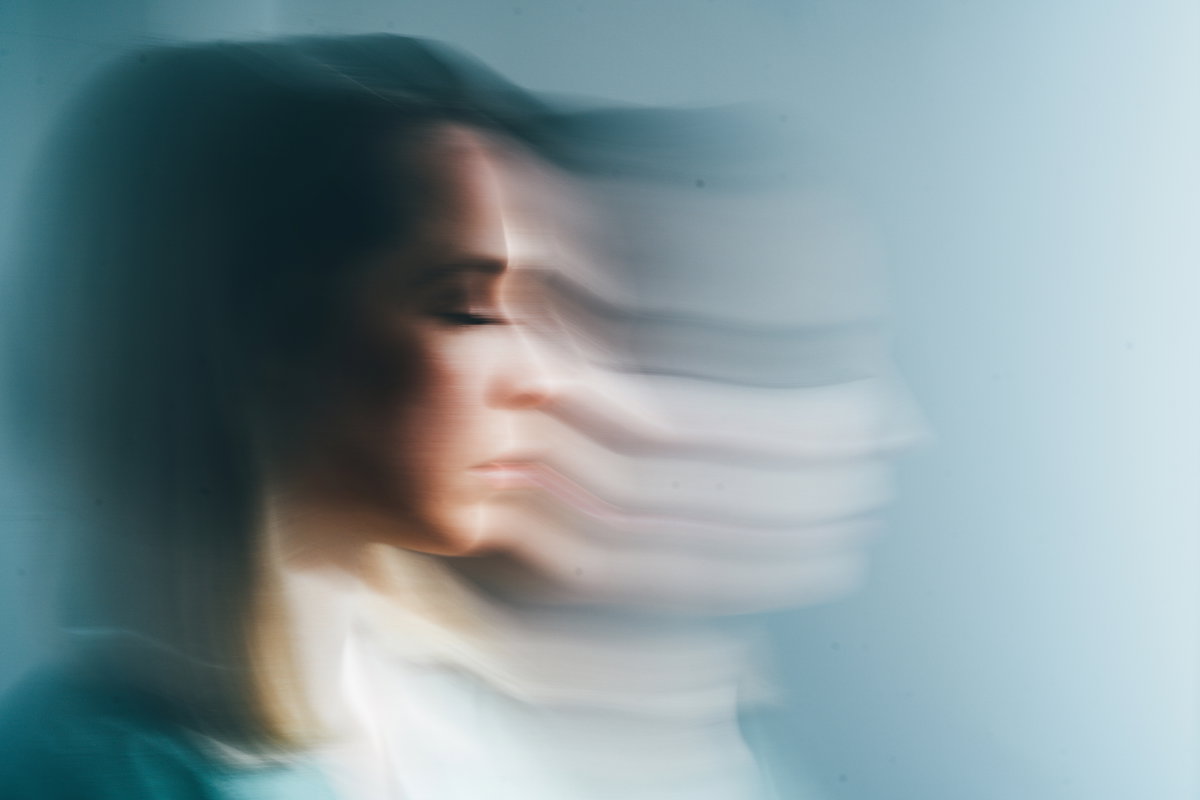 Eine Frau wirkt verzerrt vor blauem Hintergrund