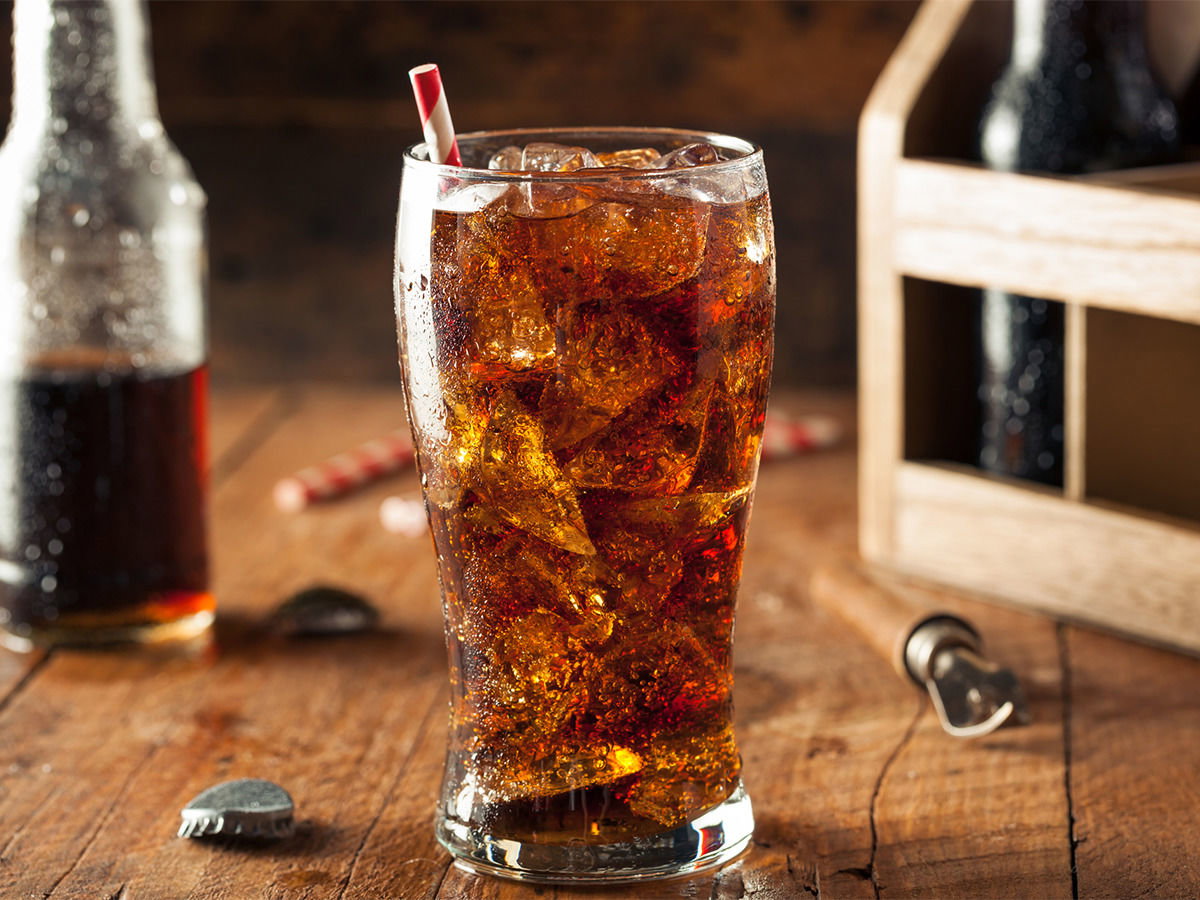 Ein Glas Cola mit Eiswürfeln und Strohhalm