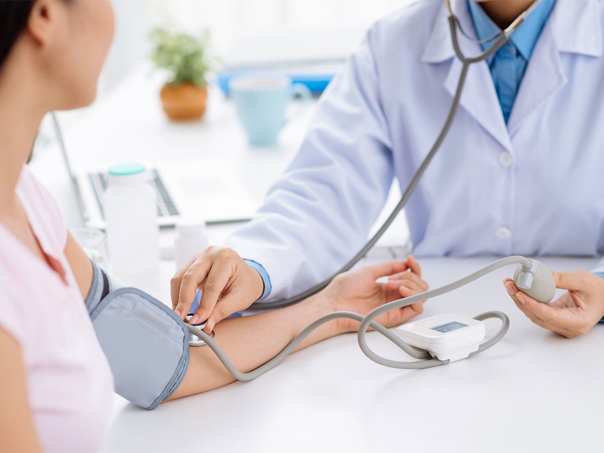 Arzt misst Blutdruck bei Patientin