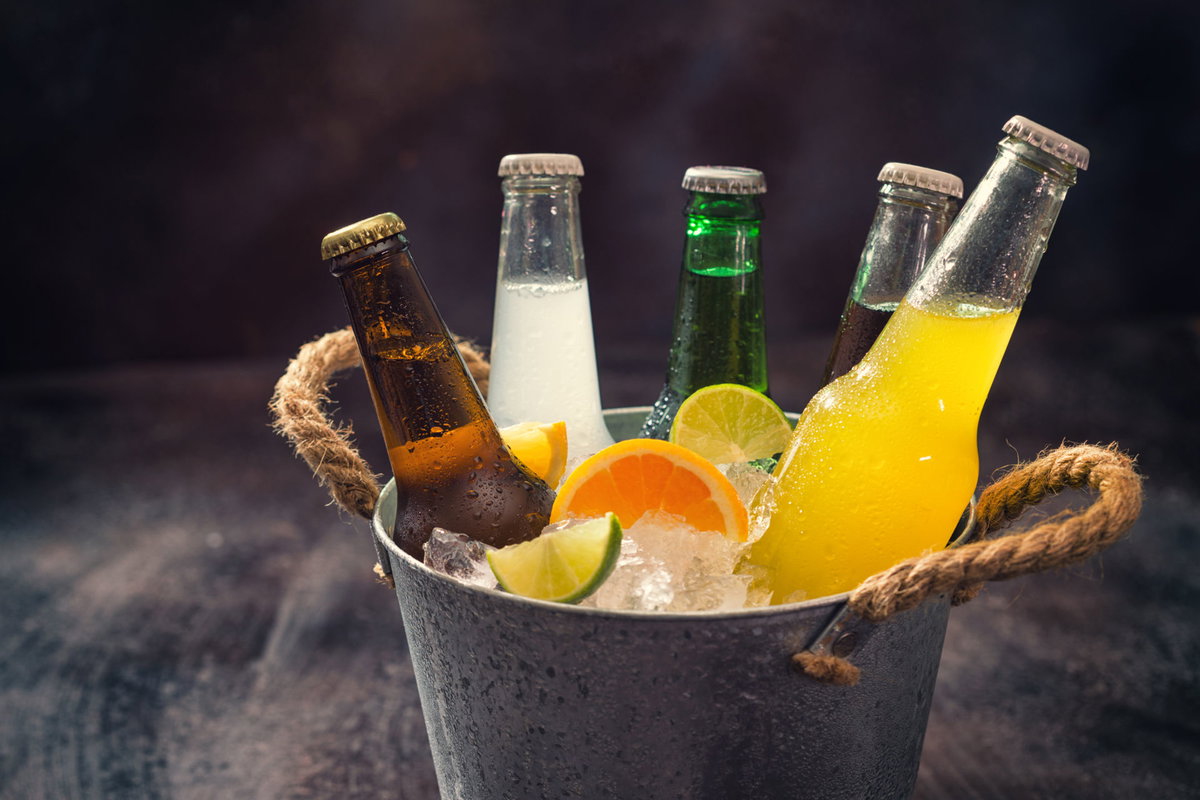 Fünf Flaschen Limonade in einem Eimer mit Eiswürfeln