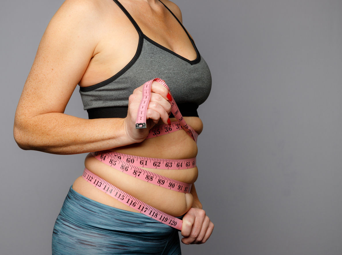 Frau mit Maßband um den Bauch