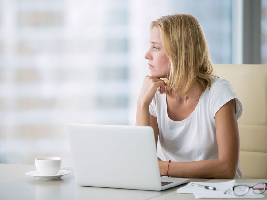 Frau am Laptop nachdenklich unkonzentriert
