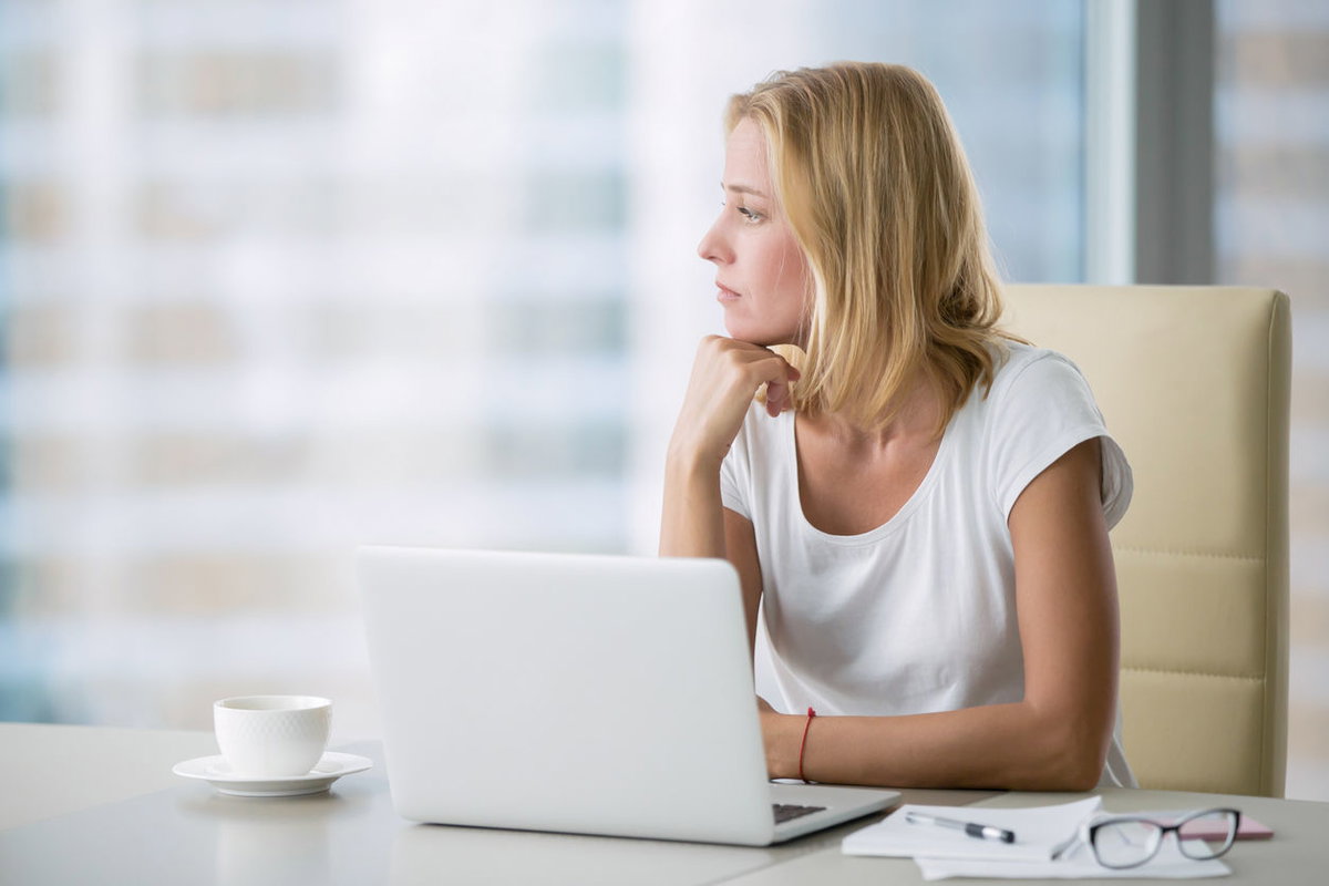 Frau am Laptop nachdenklich unkonzentriert