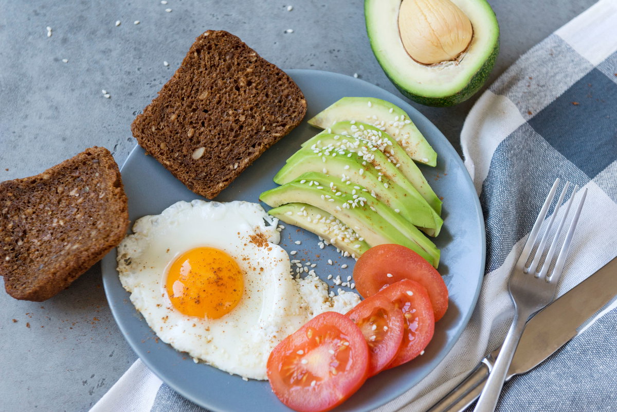 Vollkornbrot, Eier, Tomate und Avocado auf Teller