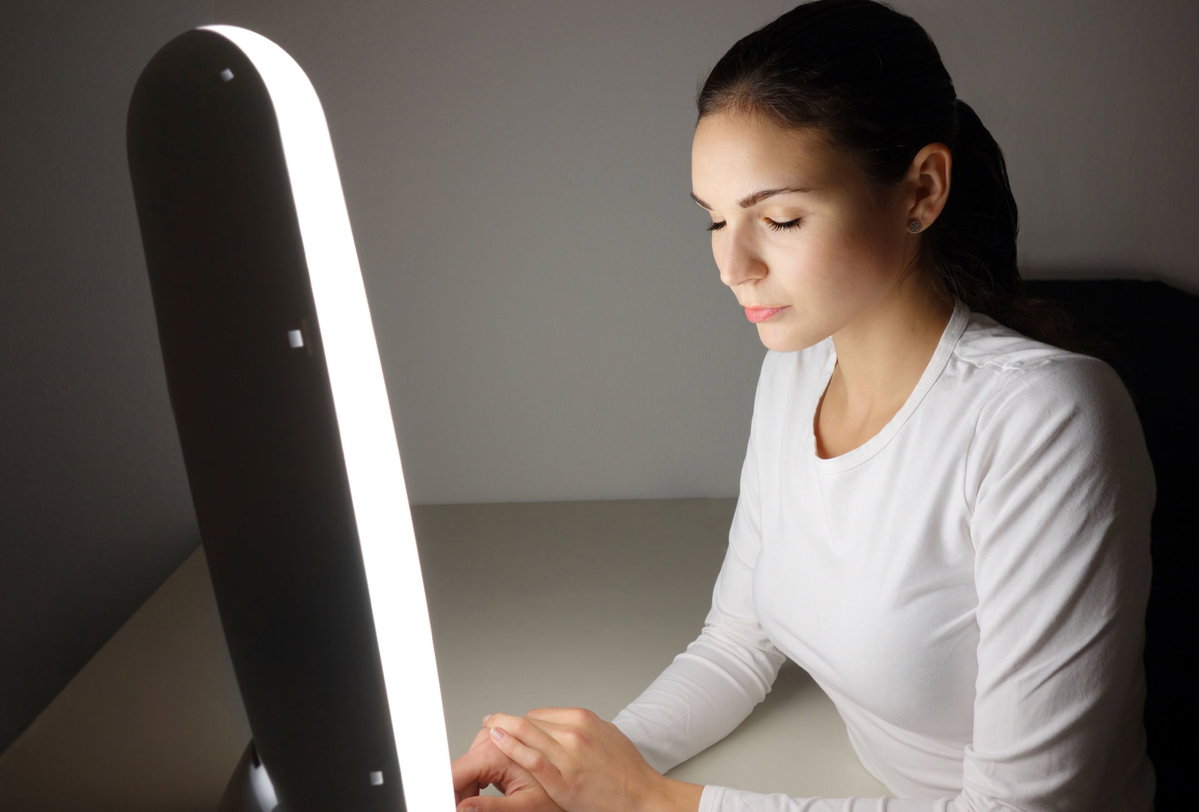 Lichttherapie Frau vor Lichtlampe