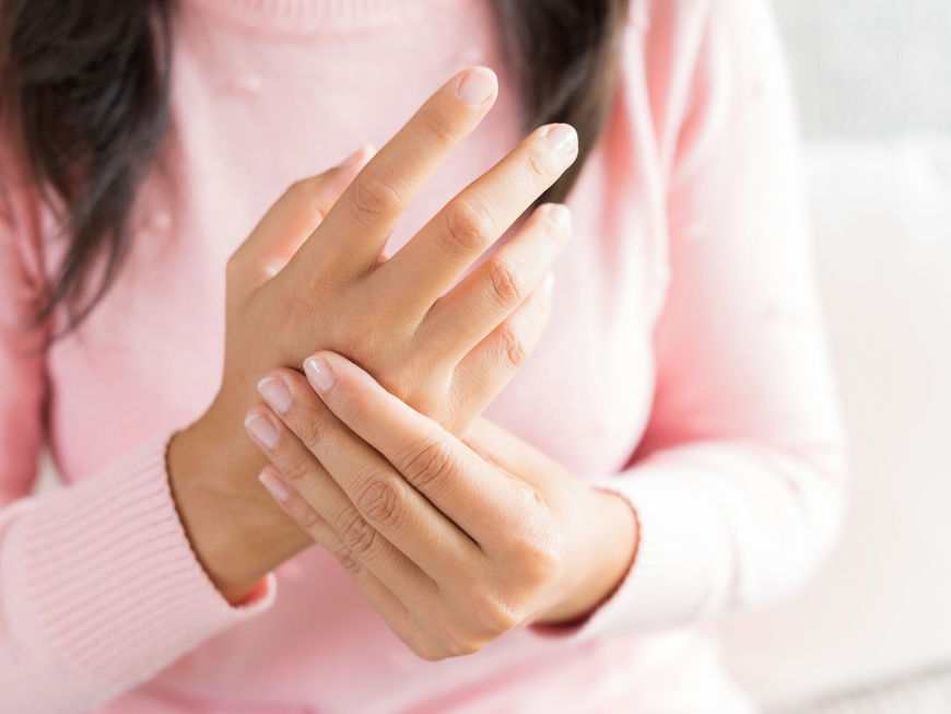 Frau hält sich die Hand