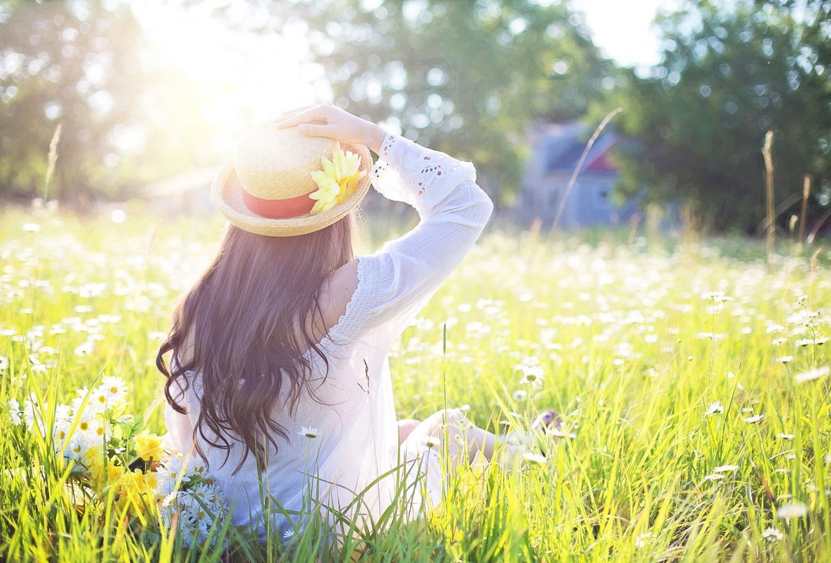 Frau sitzt auf Wiese im Frühling