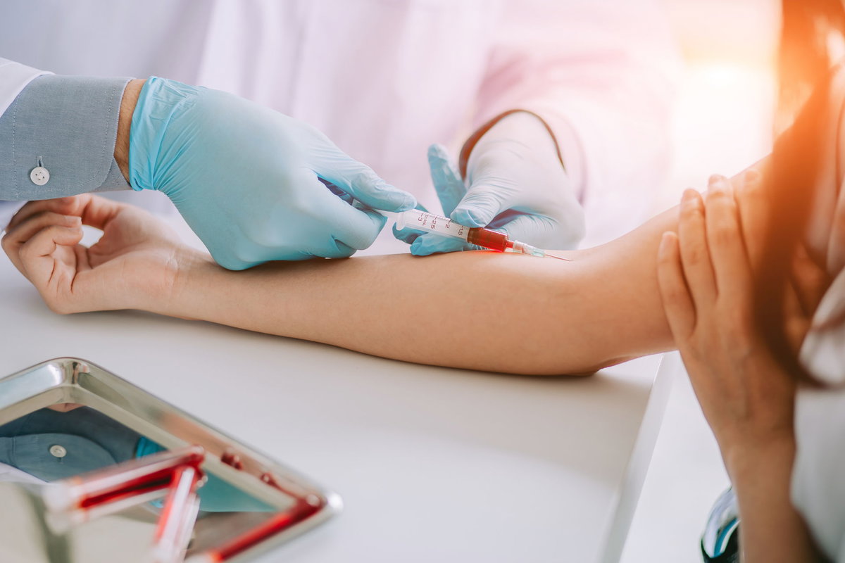 Frau wird Blut abgenommen