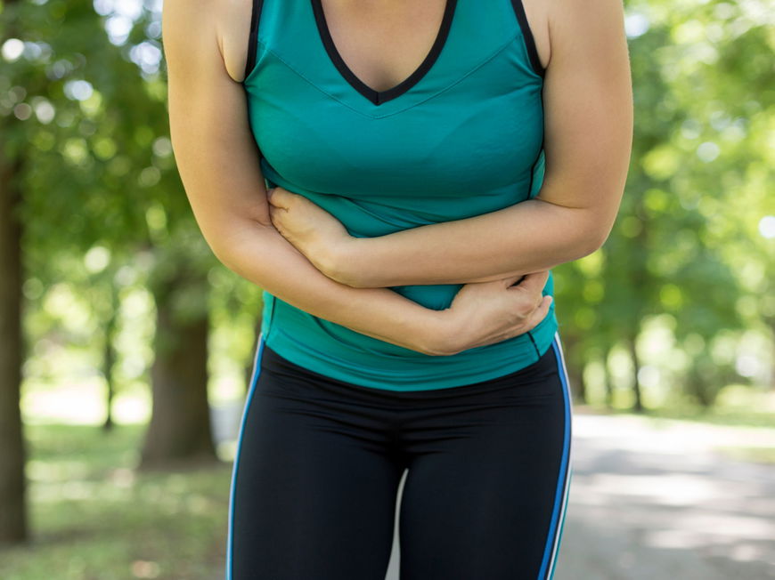 Frau beim Sport mit Bauchschmerzen