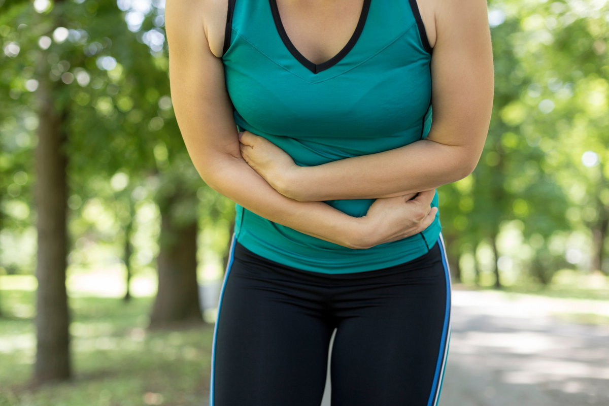 Frau beim Sport mit Bauchschmerzen